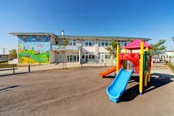 Preschool building exterior with playground on a sunny day