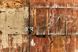 Old weathered wood panel plywood wall background texture with white paint chipping off. 