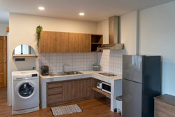 Modern light interior of kitchen with furniture and Various electrical appliances (Washing machine, refrigerator, microwave). White and brown modern kitchen with wooden clear tone in Japanese style.