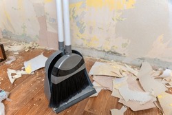 Clean up garbage after repairs.Sweep up construction debris with a brush in a dustpan.Sweeping at home.Tools for cleaning the house.Make home repairs.The dust and debris after the renovation.Handyman