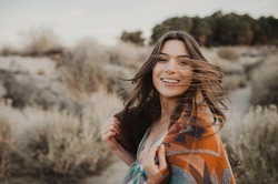 Joyful, beautiful hipster traveler girl in gypsy look and windy hair, in desert nature.  Artistic photo of young hipster traveler girl in gypsy look, in Coachella Valley 