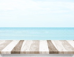 Pale wood plank table top with blurred sea and blue sky at background, Mock up template for display or montage of your product, Summer holiday concept