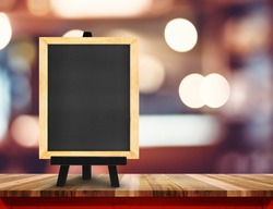 Blackboard with easel on wood table at blurred coffee shop background,Mock up for display or montage of design for online shopping promotion.