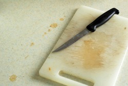 Dirty kitchen chopping board and knife.                     