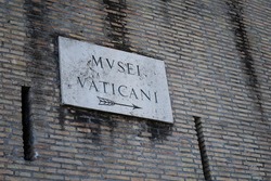Old sign on the wall pointing out the direction to the Vatican Museum. Photo taken in the Vatican City.