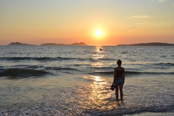 Silhouette of a woman looking the sunset at the beach