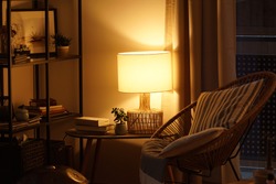 View of a cozy reader's corner with a table lamp spending warm light