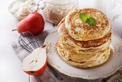 Stack of healthy low carbs oat pancakes over white wooden background