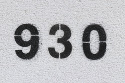Black Number 930 on the white wall. Spray paint. Number nine hundred thirty.