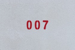RED Number 007 on the white wall. Spray paint.