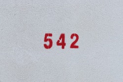 RED Number 542 on the white wall. Spray paint.