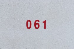 RED Number 061 on the white wall. Spray paint.