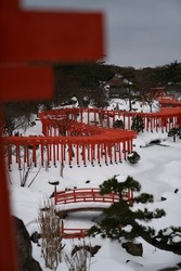 Shrine torii in the snow at Takayama Inari Shrine in Aomori Prefecture.（Japanese word: devotion）