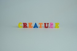 Word 'creature' on white background. Creature define as any large or small living thing that can move independently.