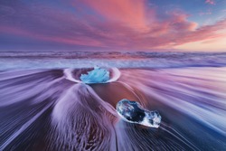 Beautiful sunset over famous Diamond beach, Iceland. This sand lava beach is full of many giant ice gems, placed near glacier lagoon Jokulsarlon
Ice rock with black sand beach in southeast Iceland