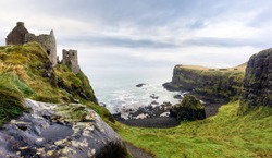 Ruined medieval Dunluce Castle on the cliff in Wild Atlantic Way, Bushmills, Northern Ireland. Filming location of popular TV series, Game of Thrones, Castle Greyjoy