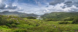 Large panorama with Irish iconic viewpoint, Ladies View, with multiple lakes, green valley, forest and mountains, Killarney, Rink of Kerry, Ireland