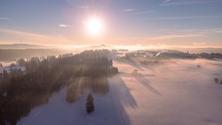 Mist over forest in canton Jura in Switzerland at sunset drone shot