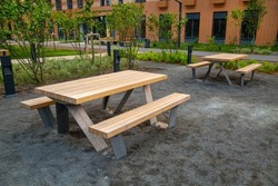 Wooden tables with benches on yellow metal supports in the courtyard of the house outdoors. Sports healthy lifestyle Hobby.