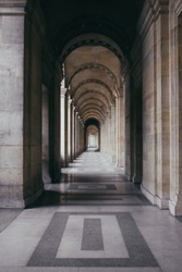 A vertical shot of an outdoor hallway of a historic building with outstanding architecture