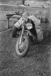 A vertical greyscale shot of a motorcycle on the ground