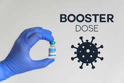 Hand in gloves holding vaccine for covid-19  Booster dose text and corona virus icon 