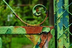 Detail of an old, rusty garden gate  Repeatedly painted over, the paint will peel off and the rust will prevail  Colourful structure 