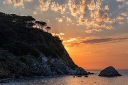 A beautiful orange sunset near a shore with cliffs