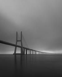 A grayscale shot of the famous Vasco da Gama cable-stayed bridge in Portugal over the Tagus river
