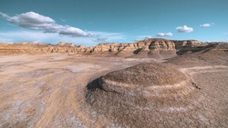 A landscape view of Bardenas Reales semi-desert with rock formations under a blue cloudy sky