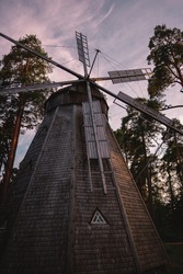 A vertical low angle shot of the windmill surrounded by trees 