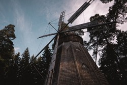 A low angle shot of the windmill surrounded by trees 