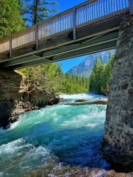 A vertical shot of a bridge over the McDonald Creek in Glacier National Park, Montana