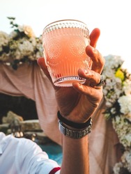 A vertical shot of a Caucasian bartender making cocktails at the venue of a fancy pool party
