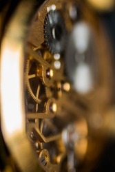 A selective focus shot of the detail of the internal mechanism of a vintage analog clockwork