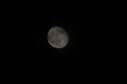 A grayscale shot of the moon at night on a black background