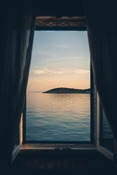 A vertical shot of the beach sunset through the window   Cres, Croatia