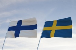 Flags of SWEDEN and FINLAND waving with cloudy blue sky background, 3D rendering WAR 3 EUROPE
