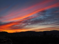 panoramic view of the silhouette of the city of Linz in sunset with beautiful small clouds, city skyline in sunset