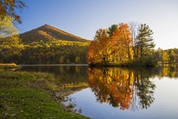 A beautiful landscape view of Peaks of Otter Lake in the autumn on a beautiful sunny day in Virginia, United States