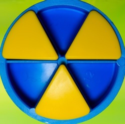 A closeup shot of texture background of Trivial Pursuit blue and yellow colors on a green background