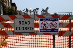 A closeup shot of forbidding signs stating that the road is closed in Newport Beach, California