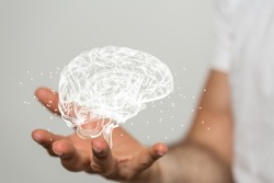 A blurred male hand holding a 3d human mind concept of Artificial intelligence on a gray background