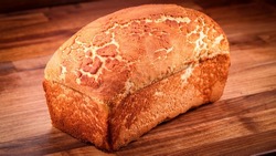 A closeup of a fresh loaf of bread on the wooden surface 