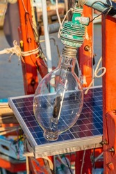 A halogen lamp with a solar battery charging station on the deck of a fisherman's boat