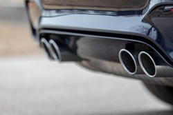 A soft focus of a quad pipe exhaust of a modified car