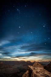 On the edge of cliff in Grand Canyon National Park under the sky full of stars and milky way