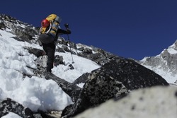A person climbing Ama Dablam Himalaya Nepal on a sunny day
