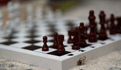 A closeup shot of the arranged brown pieces on a chess board