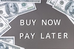 Buy Now Pay Later concept  Dollar banknotes and text message on gray board